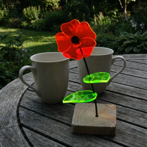 Little Susi 6 SunForm-Sonnenfänger Sonnenfängerin Little Susi mit Standfuß auf einem vergrauten Terrassentisch mit 2 Kaffeebechern im Hintergrund